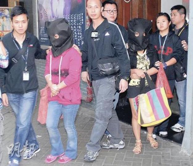 陀槍師姐（右一）喬裝買餸師奶，在北角區拘捕兩名混入街市扒竊財物的印尼女傭，涉案兩疑犯事後被蒙頭帶署。（劉友光攝）