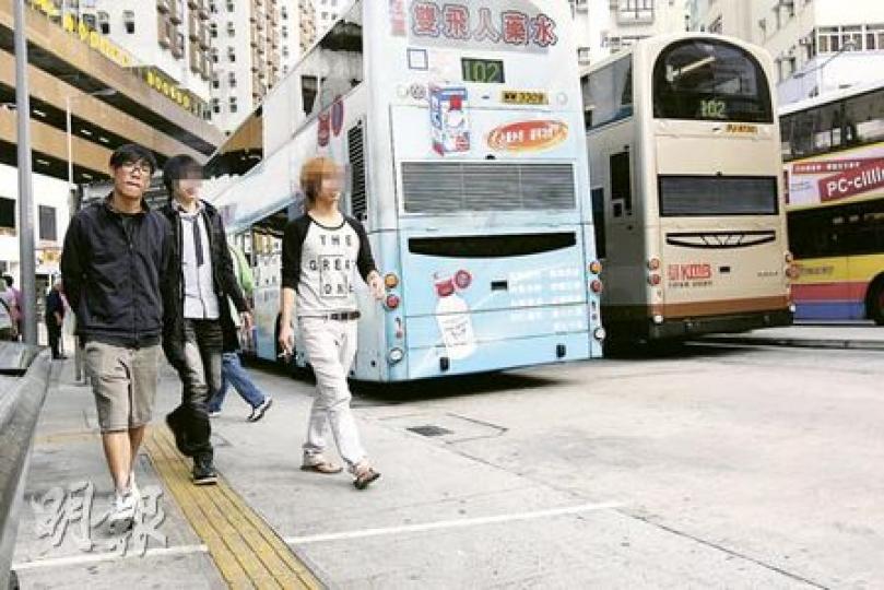 筲箕灣巴士總站僅在港鐵站出口旁邊劃了一條白線,煙民匆匆路過,隨時觸犯法例。圖中拿着香煙的市民(右及中)便位處禁煙區內。(郭慶輝攝) 筲箕灣巴士總站僅在港鐵站出口旁邊劃了一條白線,煙民匆匆路過,隨時觸犯法例。圖中拿着香煙的市民(右及中)便位處禁煙區內。(郭慶輝攝)