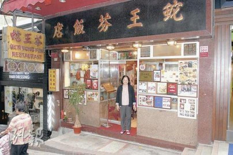 蛇王芬飯店開業近70年，於1989年遷入中環閣麟街，店外貼滿有關飯店的推介報道和獎項。穿黑色外套者為飯店老闆娘吳太。（蘇偉明攝）