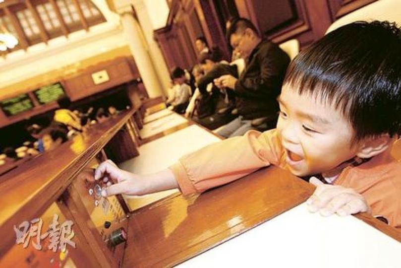 立法會明年遷至添馬艦新大樓，位於中環的大樓昨天舉行最後一次開放日，吸引不少市民參觀，更可親身感受立法會議員平日在議事廳內投票的情况。（李紹昌攝）立法會主席曾鈺成（右）親自為參觀市民及學生講解立法會運作，例如介紹議員平日如何就議案、法例投票。（李紹昌攝）不少市民昨日趁立法會最後一次開放日參觀，大批人在門外等候入場。（李紹昌攝）