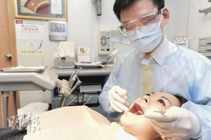 香港牙科學會副會長王志偉（右）表示，周三起一連7天共有75名牙科醫生為市民免費檢查口腔健康，預計每名醫生可服務20名市民。（尹錦恩攝）