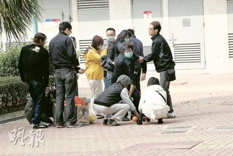 中二男生連駿鴻父母及親友在墮樓現場拜祭，部分親友神情悲傷，要旁人攙扶安慰。（黃雄攝）