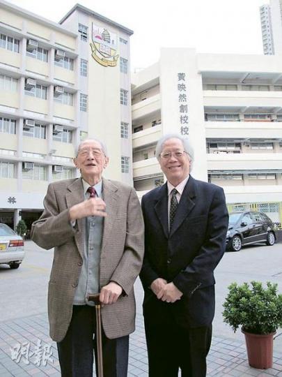 民生書院前任校監徐添福(左)及現任校監黃鉅鴻(右),口述民生書院歷史。背後大樓上的校徽位置,據說曾掛上英式大笨鐘,由於受舊啟德機場音頻影響,大笨鐘走慢30分鐘,令附近居民經常遲到還向學校投訴,最後傳聞被賣往南洋商場。(彭美芳攝) 民生書院前任校監徐添福(左)及現任校監黃鉅鴻(右),口述民生書院歷史。背後大樓上的校徽位置,據說曾掛上英式大笨鐘,由於受舊啟德機場音頻影響,大笨鐘走慢30分鐘,令附近居民經常遲到還向學校投訴,最後傳聞被賣往南洋商場。(彭美芳攝)