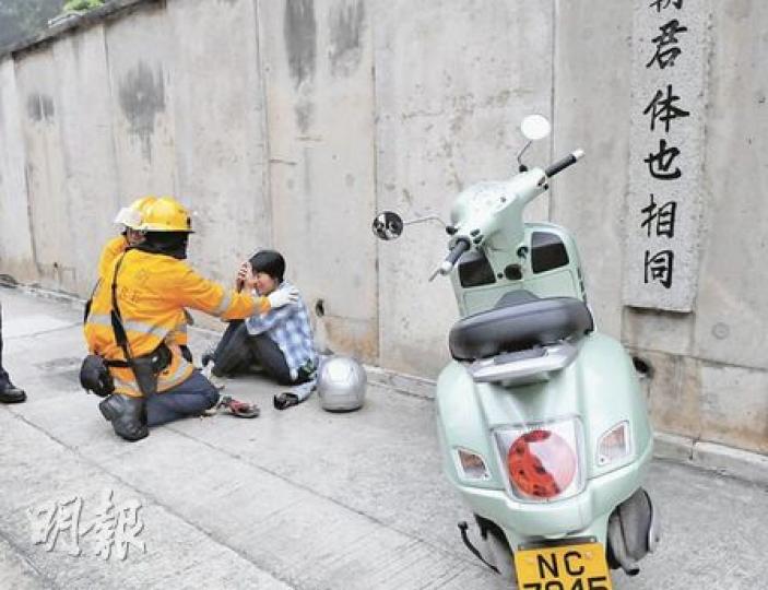 意外後,女鐵騎士坐在黄泥涌道的行人路等待救援,她右腳受輕傷,送院治理。(林錫禮攝) 意外後,女鐵騎士坐在黄泥涌道的行人路等待救援,她右腳受輕傷,送院治理。(林錫禮攝)