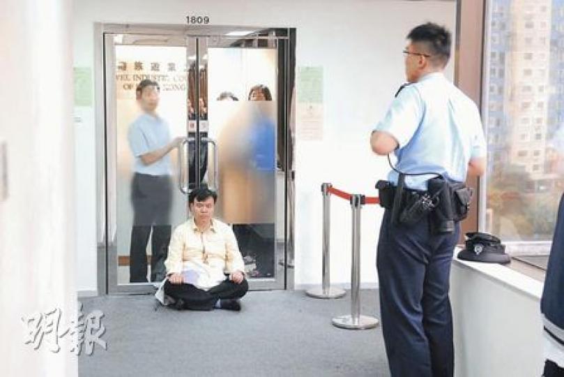 導遊總工會會長黃嘉毅(黃衫者)昨日到旅遊業議會抗議下月推行「一團一導遊」措施,聲稱曾被保安員箍頸,報警後於議會門外靜坐抗議。(何朝財攝) 導遊總工會會長黃嘉毅(黃衫者)昨日到旅遊業議會抗議下月推行「一團一導遊」措施,聲稱曾被保安員箍頸,報警後於議會門外靜坐抗議。(何朝財攝)