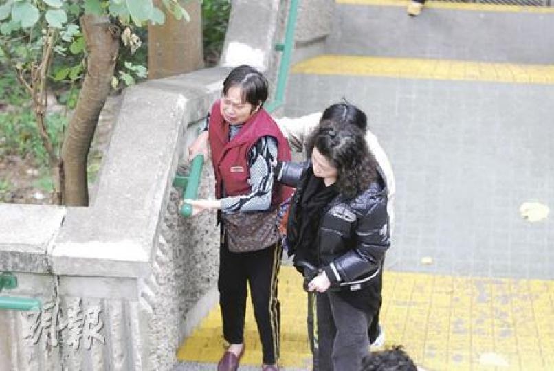 因中風不良於行的鍾老太(左),短短半年間痛失丈夫及愛子,縱然要由親友攙扶上落樓梯,仍堅持到天馬苑球場拜祭亡兒。(何朝財攝) 因中風不良於行的鍾老太(左),短短半年間痛失丈夫及愛子,縱然要由親友攙扶上落樓梯,仍堅持到天馬苑球場拜祭亡兒。(何朝財攝)