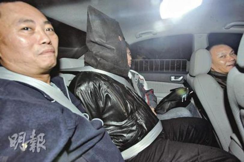 涉嫌扑頭劫殺芭蕾舞學校校長徐滿芬的冷血疑匪,被黑布蒙頭、戴上手銬及在兩名重案組探員押解下由私家車載往警署扣查。(樊銳昌攝) 涉嫌扑頭劫殺芭蕾舞學校校長徐滿芬的冷血疑匪,被黑布蒙頭、戴上手銬及在兩名重案組探員押解下由私家車載往警署扣查。(樊銳昌攝)