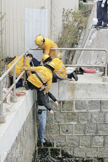 數名消防員將在碼頭邊「笨豬跳」吊頸男子扯回岸邊。(黃雄攝) 數名消防員將在碼頭邊「笨豬跳」吊頸男子扯回岸邊。(黃雄攝)