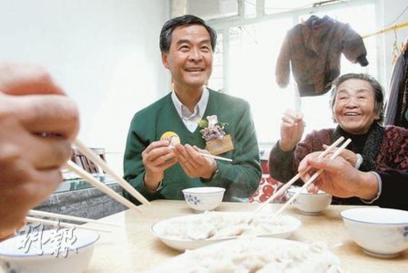 行會召集人梁振英昨出席送暖大行動，到李鄭屋邨探訪長者，更一起吃餃子。（林振東攝）