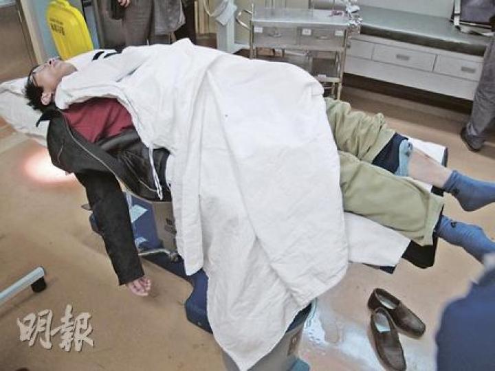 廣州維權律師劉士輝前日被不明人物打傷,送院治療時躺在病牀等醫生診治。(明報記者攝) 廣州維權律師劉士輝前日被不明人物打傷,送院治療時躺在病牀等醫生診治。(明報記者攝)
