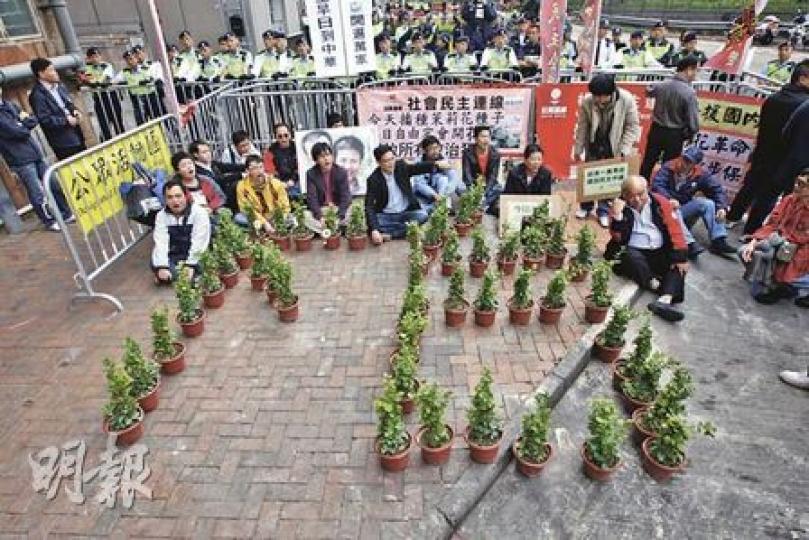 社民連成員支援內地的「茉莉花革命」行動,昨日在中聯辦門外,把數十盆茉莉花砌成「下台」兩字。(李紹昌攝) 社民連成員支援內地的「茉莉花革命」行動,昨日在中聯辦門外,把數十盆茉莉花砌成「下台」兩字。(李紹昌攝)