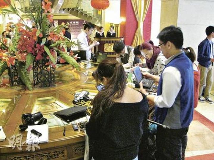 北京飯店電梯大堂中有一張圓形的裝飾枱,昨日被大批港澳記者當作辦公枱。(陳小強攝) 北京飯店電梯大堂中有一張圓形的裝飾枱,昨日被大批港澳記者當作辦公枱。(陳小強攝)