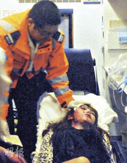 公主道私家車炮彈飛車車禍中,一名的士女乘客飛來橫禍,臉部無辜受傷,她被送上救護車後救護員努力助她止血。(蔡方山攝) 公主道私家車炮彈飛車車禍中,一名的士女乘客飛來橫禍,臉部無辜受傷,她被送上救護車後救護員努力助她止血。(蔡方山攝)