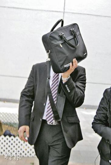 現役警員鍾志勇(以公文袋掩臉)昨在沙田裁判法院就盜竊罪受審。(梁珮珊攝) 現役警員鍾志勇(以公文袋掩臉)昨在沙田裁判法院就盜竊罪受審。(梁珮珊攝)