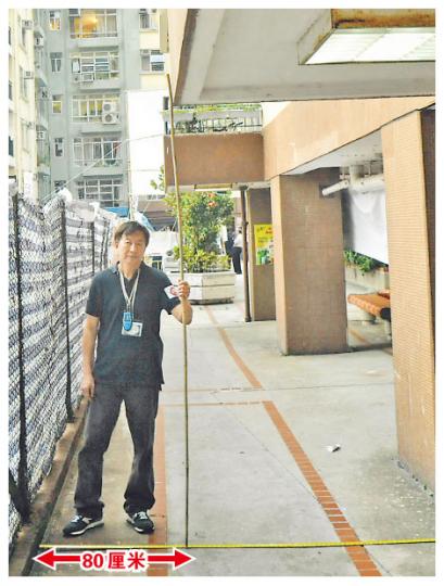 反興建美孚屏風樓小組召集人葉少舟,以拉尺展示新地盤圍網與8期露台之間只相隔80厘米。(葉漢華攝) 反興建美孚屏風樓小組召集人葉少舟,以拉尺展示新地盤圍網與8期露台之間只相隔80厘米。(葉漢華攝)