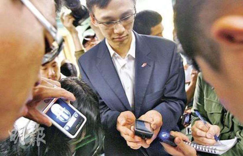 「我要和記者有傾有講!」卧病在牀的政制及內地事務局長林瑞麟昨日要求透過新聞官員(中)的電話與記者即時對答,而非由新聞官先行錄音讓他稍後回答,故一眾記者在病房外與林瑞麟隔空答問。(林振東攝) 「我要和記者有傾有講!」卧病在牀的政制及內地事務局長林瑞麟昨日要求透過新聞官員(中)的電話與記者即時對答,而非由新聞官先行錄音讓他稍後回答,故一眾記者在病房外與林瑞麟隔空答問。(林振東攝)