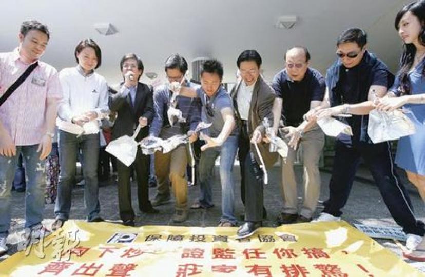 遊行人士借撕破「鑊鏟」,抗議當局漠視市場日益嚴重的「向下炒」活動。(林振東攝) 遊行人士借撕破「鑊鏟」,抗議當局漠視市場日益嚴重的「向下炒」活動。(林振東攝)