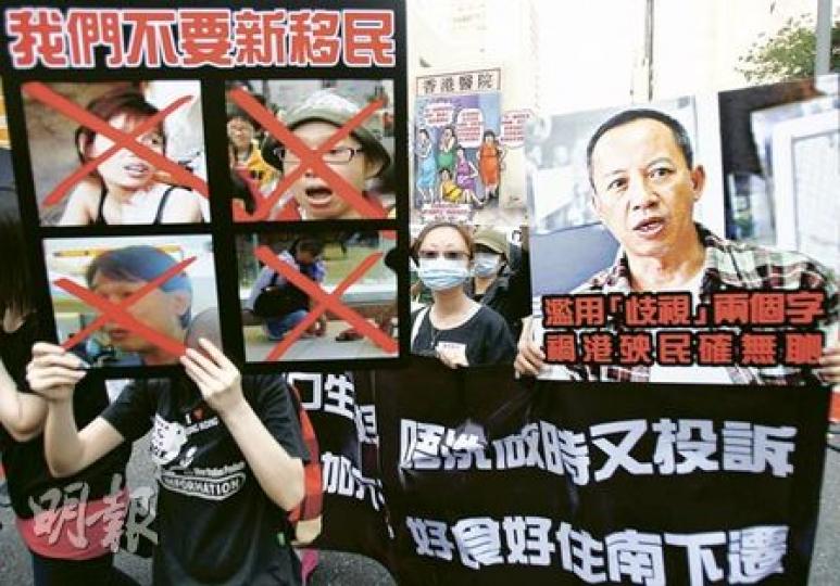 近200市民響應網上號召,上街反對派錢給新移民,又有人高舉標語指「我們不要新移民」。他們又針對社協主任何喜華,指其濫用「歧視」兩字。(林振東攝) 近200市民響應網上號召,上街反對派錢給新移民,又有人高舉標語指「我們不要新移民」。他們又針對社協主任何喜華,指其濫用「歧視」兩字。(林振東攝)