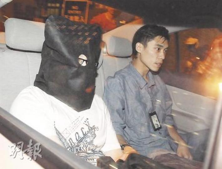涉用改裝購物袋暗藏攝錄器材偷拍裙底春光的疑犯,被黑布蒙頭帶返警署調查。(衛永康攝) 涉用改裝購物袋暗藏攝錄器材偷拍裙底春光的疑犯,被黑布蒙頭帶返警署調查。(衛永康攝)