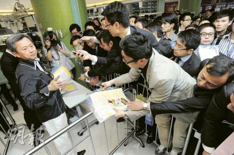 為營造「尚城」售樓處的氣氛熾熱,長實執行董事趙國雄(左)親自向代理們「派貨」。(尹錦恩攝)(明報製圖) 為營造「尚城」售樓處的氣氛熾熱,長實執行董事趙國雄(左)親自向代理們「派貨」。(尹錦恩攝)(明報製圖)