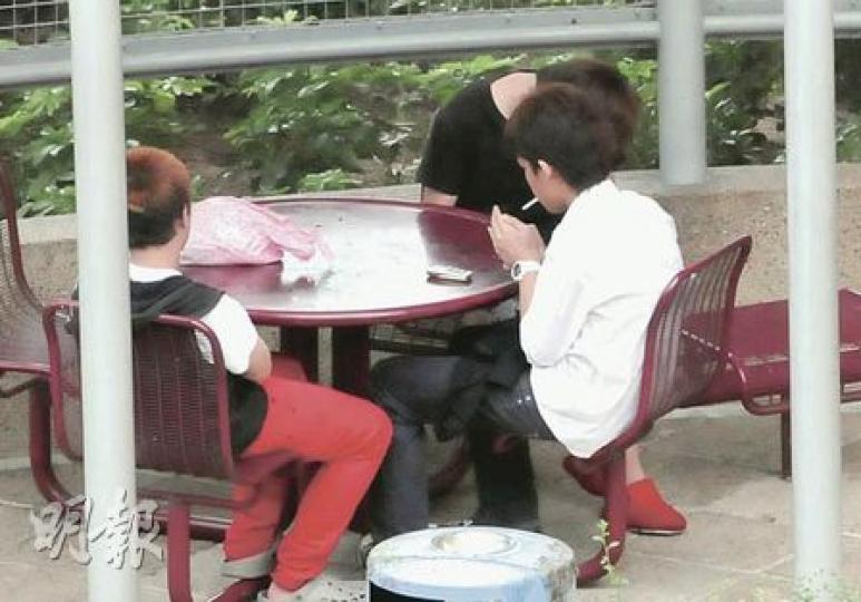 記者昨午在明德邨亦發現疑似童黨蹤影，3名少年在花園內吸煙及午睡，良久不願離去。（林錫禮攝）