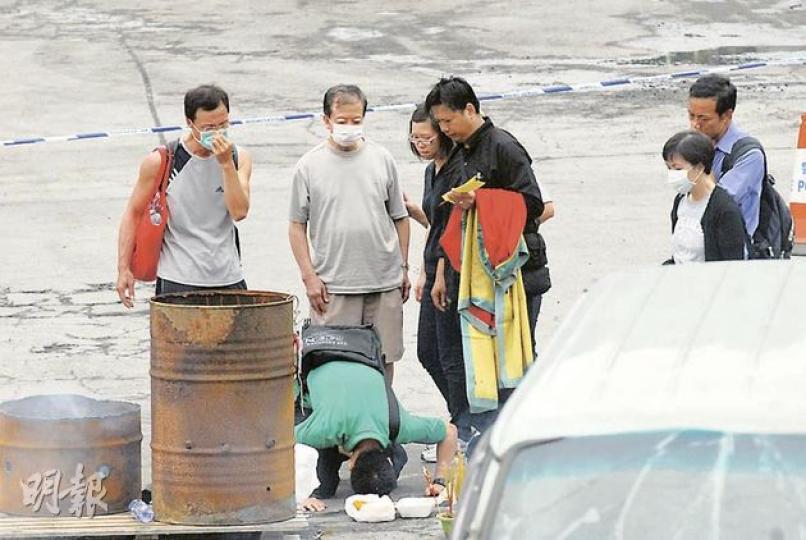 24歲死者何賜豪的家人昨午重返現場拜祭，其間何的胞兄（綠衣者）跪下，向胞弟的出事位置三磕頭，見者心酸。（梁琬珊攝）
