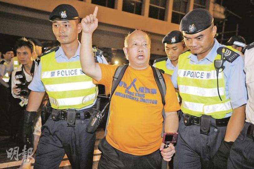 七一後的凌晨,香港人權監察總幹事羅沃啟在中環干諾道中觀察警方清場行動,突遭兩名警務人員阻撓,一度企圖把他帶離現場送上警車。(何家達攝) 七一後的凌晨,香港人權監察總幹事羅沃啟在中環干諾道中觀察警方清場行動,突遭兩名警務人員阻撓,一度企圖把他帶離現場送上警車。(何家達攝)