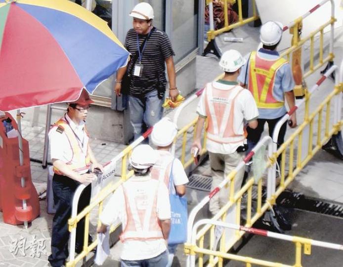 本報記者昨午到添馬艦地盤附近觀察,見10分鐘內有29名工人進入工地,其中13人未有出示工作卡便能輕易進入工地範圍。(吳光熙攝) 本報記者昨午到添馬艦地盤附近觀察,見10分鐘內有29名工人進入工地,其中13人未有出示工作卡便能輕易進入工地範圍。(吳光熙攝)