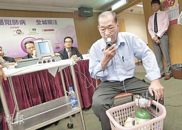 慢阻肺病患者陳伯伯示範肺功能測試,先深深吸入一口氣,然後盡全力吹入測量機的軟管。(葉漢華攝) 慢阻肺病患者陳伯伯示範肺功能測試,先深深吸入一口氣,然後盡全力吹入測量機的軟管。(葉漢華攝)