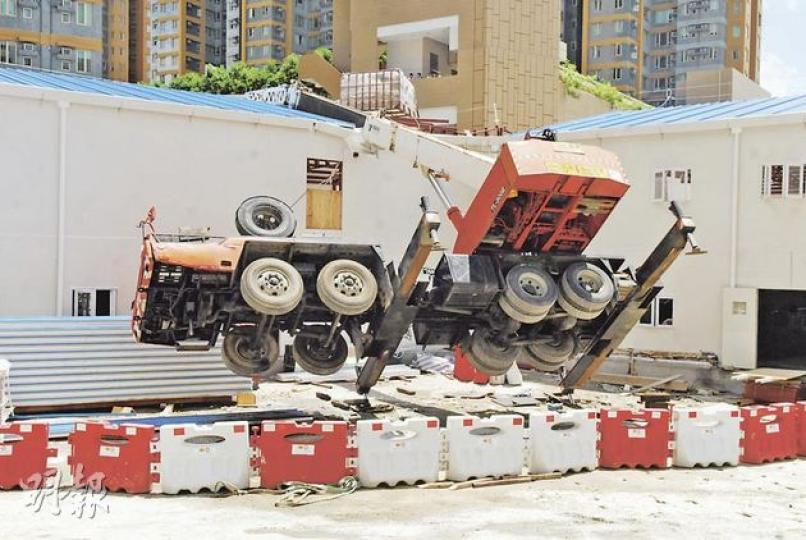 吊臂車被30米長的支架扯起翻側,車身亦凌空離地,幸操控員及時逃離,並無受傷。(梁琬珊攝) 吊臂車被30米長的支架扯起翻側,車身亦凌空離地,幸操控員及時逃離,並無受傷。(梁琬珊攝)
