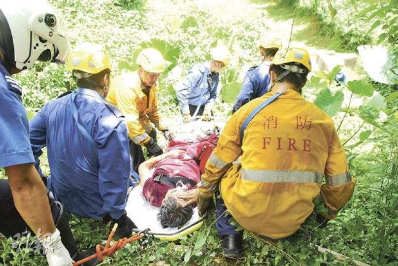 中年婦離家失蹤，其後在山中尋回，消防員將其固定在擔架牀上送院檢驗。（梁琬珊攝）