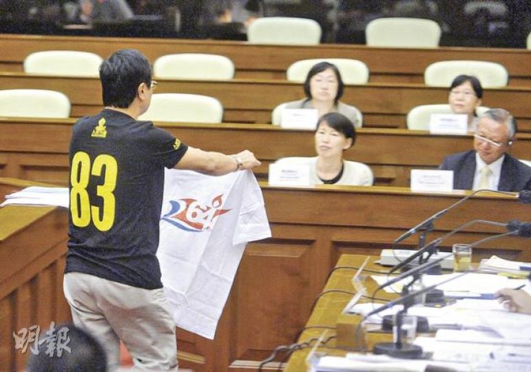 人民力量議員黃毓民(左)拿着六四字眼T恤走上保安局長李少光(右)及警務處長曾偉雄跟前,指這不是危險武器,更將T恤擲到曾偉雄身上。(李澤彤攝) 人民力量議員黃毓民(左)拿着六四字眼T恤走上保安局長李少光(右)及警務處長曾偉雄跟前,指這不是危險武器,更將T恤擲到曾偉雄身上。(李澤彤攝)