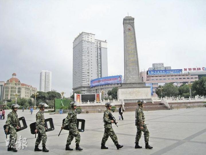 手持自動步槍及防暴裝備的武警昨日在烏魯木齊人民廣場巡邏。(明報記者攝) 手持自動步槍及防暴裝備的武警昨日在烏魯木齊人民廣場巡邏。(明報記者攝)