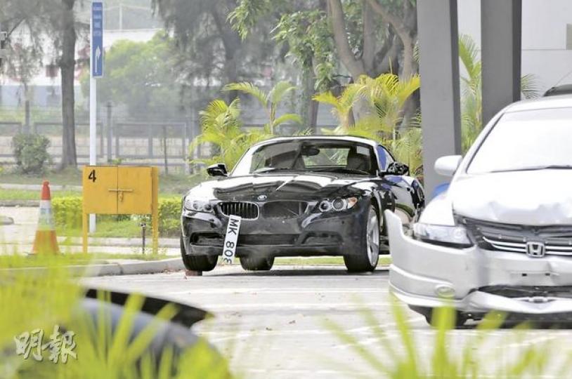 撞傷工人的黑色寶馬跑車車頭輕微損毁,車牌歪斜,現由警方扣查等候檢驗。(林錫禮攝) 撞傷工人的黑色寶馬跑車車頭輕微損毁,車牌歪斜,現由警方扣查等候檢驗。(林錫禮攝)