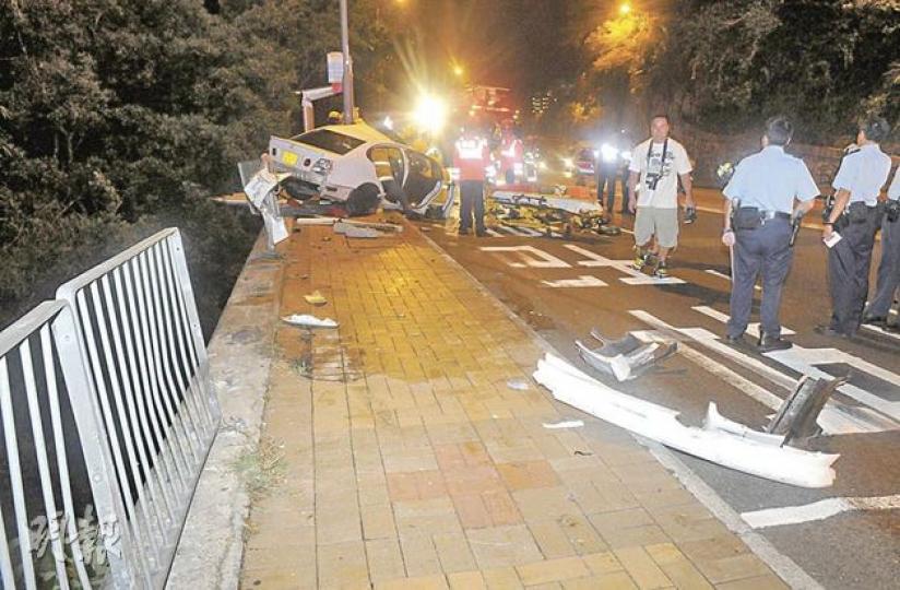孔泳雯乘坐的私家車掃毁鐵欄後撼向燈柱,僅差半個車位便跌下20米深的山坡。(蔡方山攝) 孔泳雯乘坐的私家車掃毁鐵欄後撼向燈柱,僅差半個車位便跌下20米深的山坡。(蔡方山攝)