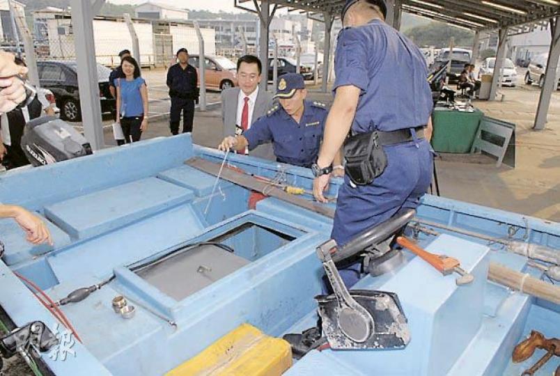 海域突擊及支援組指揮官方永佳(中間戴帽者)指出,舢舨油缸設精巧暗格,內藏總值220萬電子產品。(鍾炳然攝) 海域突擊及支援組指揮官方永佳(中間戴帽者)指出,舢舨油缸設精巧暗格,內藏總值220萬電子產品。(鍾炳然攝)