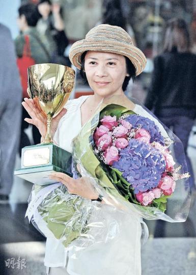 威尼斯影后葉德嫻手持鮮花、獎盃步出機場大堂,身穿便裝的她見一眾記者跪地圍訪拿咪拿到手震,更主動說﹕「我幫你攞住啦!」(葉漢華攝) 威尼斯影后葉德嫻手持鮮花、獎盃步出機場大堂,身穿便裝的她見一眾記者跪地圍訪拿咪拿到手震,更主動說﹕「我幫你攞住啦!」(葉漢華攝)
