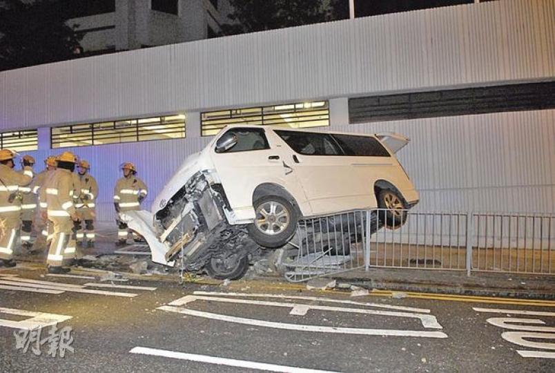 客貨車失控後半邊車身懸空擱於欄杆上,情景驚險。(鍾炳然攝) 客貨車失控後半邊車身懸空擱於欄杆上,情景驚險。(鍾炳然攝)
