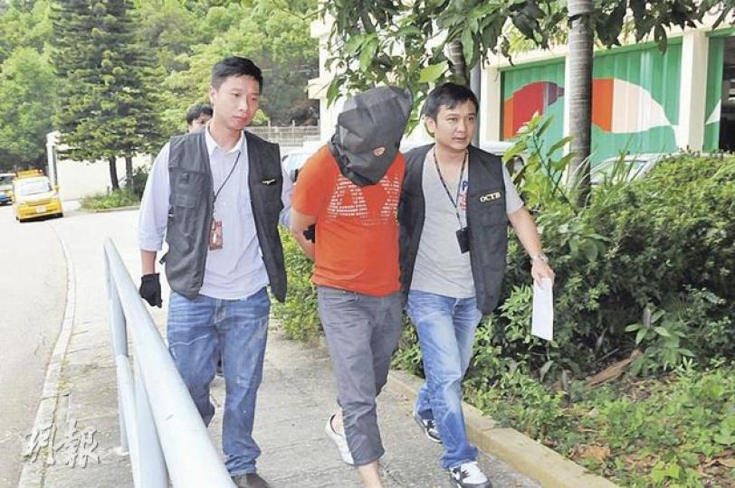 其中一名黑幫車上的男子,被警員蒙頭拘捕帶署。(林錫禮攝) 其中一名黑幫車上的男子,被警員蒙頭拘捕帶署。(林錫禮攝)