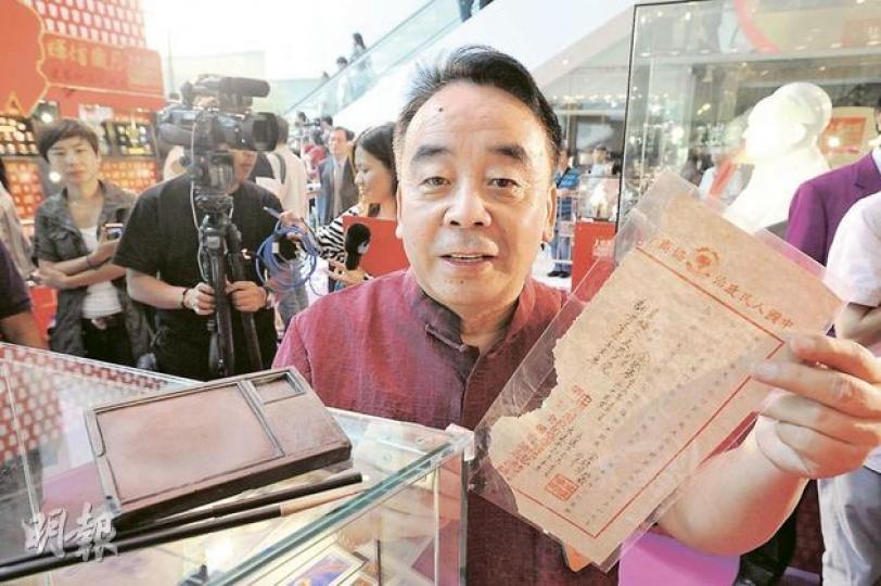 著名「紅色收藏家」金鐵華昨日在會場向參觀者解釋藏品，包括一套毛澤東曾經在1949年進駐北京後使用的毛筆和硯台（左），和一份中華人民共和國開國大典的邀請函（右）。（葉漢華攝）