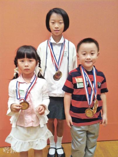 一年一度的兒童及青少年閱讀計劃昨日舉行年度頒獎禮,其中5歲女童馮恩潞(左)一年內閱讀4277本書獲得傑出表現獎;施貝然(中)的《兒童學唐詩》閱讀報告獎,而梁綽廷(右)則與父親合作畫了一幅有關《腳踏實地的水牛阿力》的圖畫而獲獎。(楊嘉欣攝) 一年一度的兒童及青少年閱讀計劃昨日舉行年度頒獎禮,其中5歲女童馮恩潞(左)一年內閱讀4277本書獲得傑出表現獎;施貝然(中)的《兒童學唐詩》閱讀報告獎,而梁綽廷(右)則與父親合作畫了一幅有關《腳踏實地的水牛阿力》的圖畫而獲獎。(楊嘉欣攝)