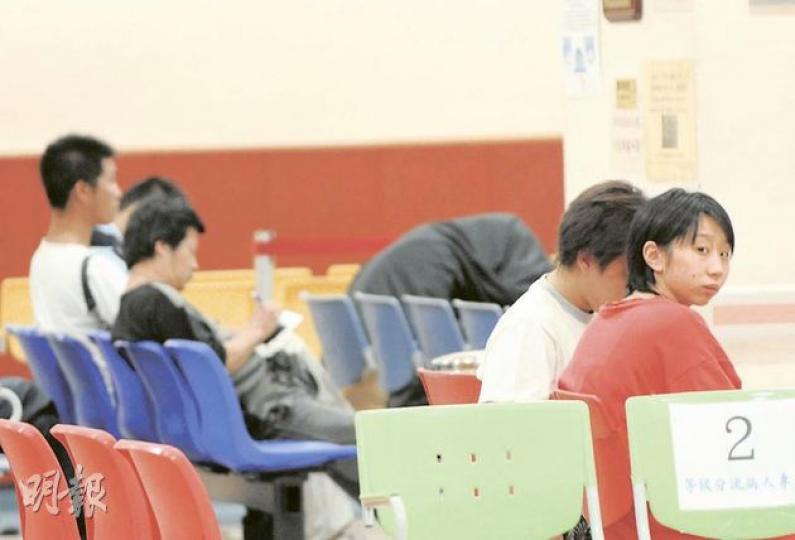 5名男女對包括一分居年輕夫婦疑因感情問題，各自攜同新歡「講數」時大打出手，送院治理，案中分居女事主（右一）與男友在醫院內等候診治。最左白衣者為其分居丈夫。（蔡方山攝）