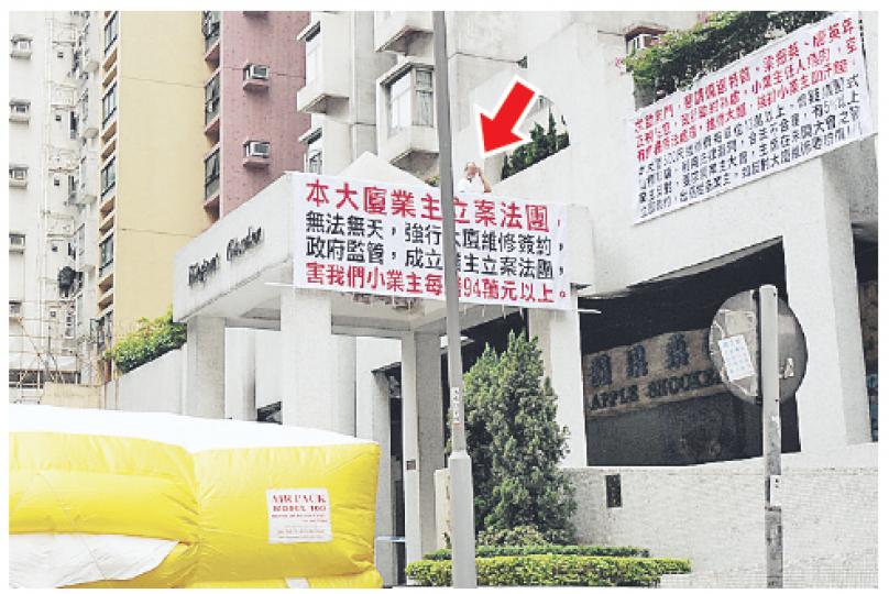 企圖跳樓抗議的男戶主(箭嘴示),其橫額寫有向下屆特首疑似候選人唐英年及梁振英求助的字句。(蔡方山攝) 企圖跳樓抗議的男戶主(箭嘴示),其橫額寫有向下屆特首疑似候選人唐英年及梁振英求助的字句。(蔡方山攝)