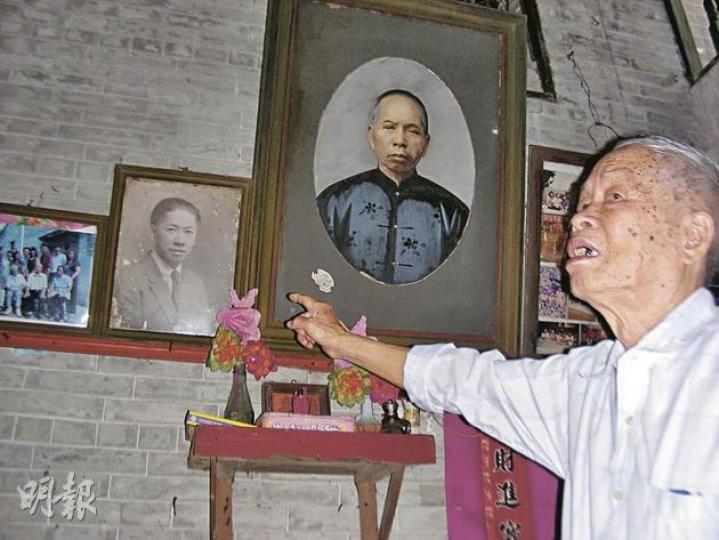 駱家輝的六叔公指着掛在牆上的舊照片,向駱氏兄妹介紹親人和祖先的情况。(李泉攝)駱家輝親自爬上兩米多高的木梯,將父親的遺像(圖)擺上祖先靈位的左下邊。(李泉攝)駱家輝在祖墳前跪下拜祭。(李泉攝) 駱家輝的六叔公指着掛在牆上的舊照片,向駱氏兄妹介紹親人和祖先的情况。(李泉攝)駱家輝親自爬上兩米多高的木梯,將父親的遺像(圖)擺上祖先靈位的左下邊。(李泉攝)駱家輝在祖墳前跪下拜祭。(李泉攝)