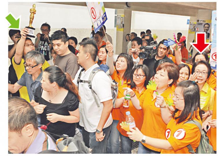 工聯會陳婉嫻(紅箭嘴示)昨於近百助選團包圍下落區拉票,人民力量任亮憲(綠箭嘴示)手執「最佳女主角」獎座一度嘗試走向陳婉嫻,隨即被數名男子隔開。(劉焌陶攝) 工聯會陳婉嫻(紅箭嘴示)昨於近百助選團包圍下落區拉票,人民力量任亮憲(綠箭嘴示)手執「最佳女主角」獎座一度嘗試走向陳婉嫻,隨即被數名男子隔開。(劉焌陶攝)