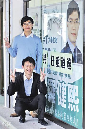 民主黨羅健熙(下)、區諾軒(上)在橫額上貼上「任重道遠」。二人笑言將全力做好地區工作,「要話畀建制派知,他們派人落嚟謀我們的位,只會嘥時間」。(劉焌陶攝) 民主黨羅健熙(下)、區諾軒(上)在橫額上貼上「任重道遠」。二人笑言將全力做好地區工作,「要話畀建制派知,他們派人落嚟謀我們的位,只會嘥時間」。(劉焌陶攝)