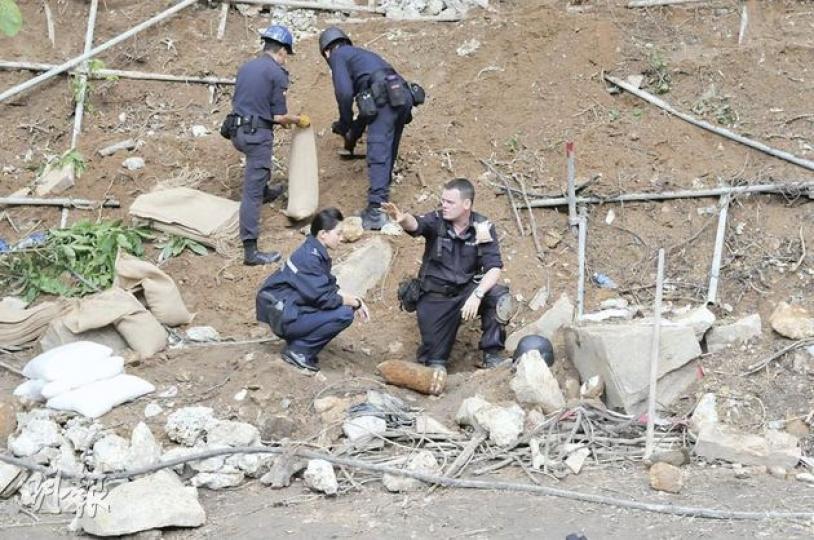 昨日出土的炮彈當中,其中一顆保存完好,體積與成人大腿相若,圖中爆炸品處理課人員需即場引爆銷毁。(林錫禮攝) 昨日出土的炮彈當中,其中一顆保存完好,體積與成人大腿相若,圖中爆炸品處理課人員需即場引爆銷毁。(林錫禮攝)