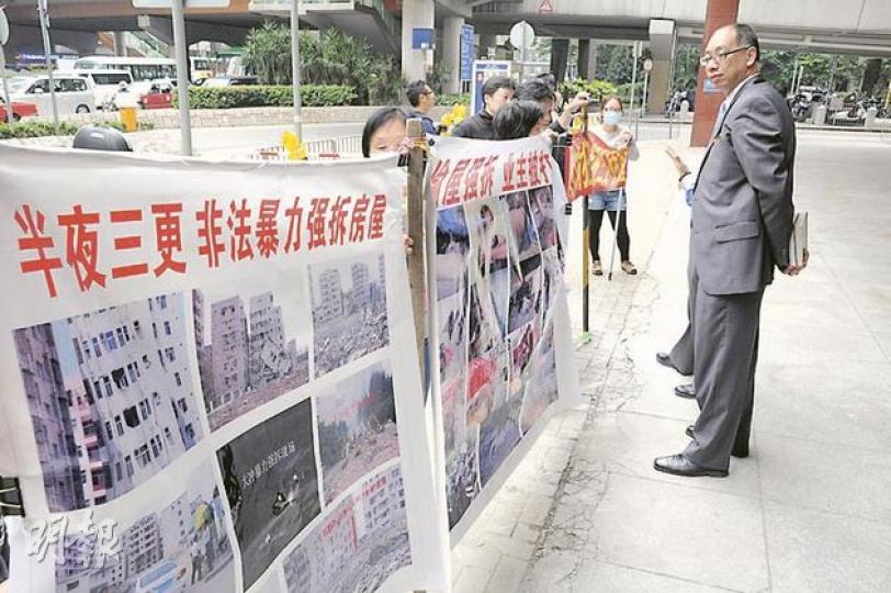 多名深圳港人拆遷戶昨到灣仔華潤置業總部門外拉橫額抗議,指發展商未經法院審判,便非法強拆他們多幢物業。(明報記者攝) 多名深圳港人拆遷戶昨到灣仔華潤置業總部門外拉橫額抗議,指發展商未經法院審判,便非法強拆他們多幢物業。(明報記者攝)