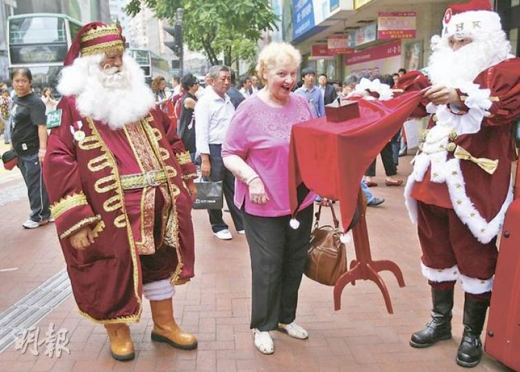 即將出戰「國際聖誕老人運動會」的聖誕老人Santa Mario高添羽(右),擁有15年魔術經驗,隨手便能表演魔術,輕輕「掂住」桌布,就能令桌子騰空升起,桌上的盒子更可變出糖果。(林振東攝) 即將出戰「國際聖誕老人運動會」的聖誕老人Santa Mario高添羽(右),擁有15年魔術經驗,隨手便能表演魔術,輕輕「掂住」桌布,就能令桌子騰空升起,桌上的盒子更可變出糖果。(林振東攝)