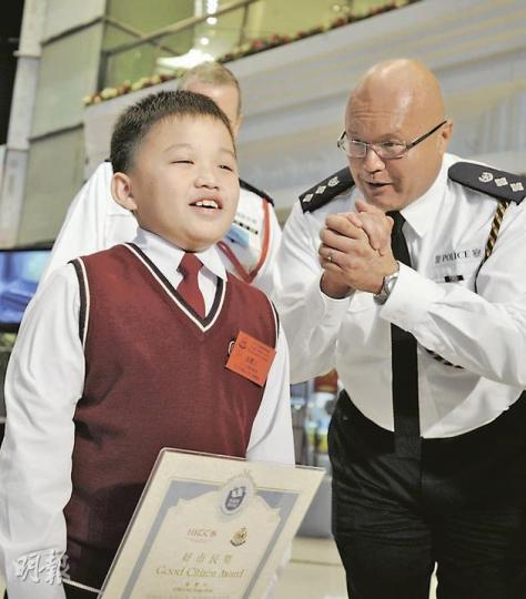今屆最年輕「好巿民」是10歲的小五生張豐正,他為秀茂坪遊樂場遊樂設施縱火案提供目擊證據,幫助警方破案。張豐生昨日獲頒獎狀後很是高興,秀茂坪警區副指揮官許德禮(右)上前恭賀他。(何家達攝) 今屆最年輕「好巿民」是10歲的小五生張豐正,他為秀茂坪遊樂場遊樂設施縱火案提供目擊證據,幫助警方破案。張豐生昨日獲頒獎狀後很是高興,秀茂坪警區副指揮官許德禮(右)上前恭賀他。(何家達攝)